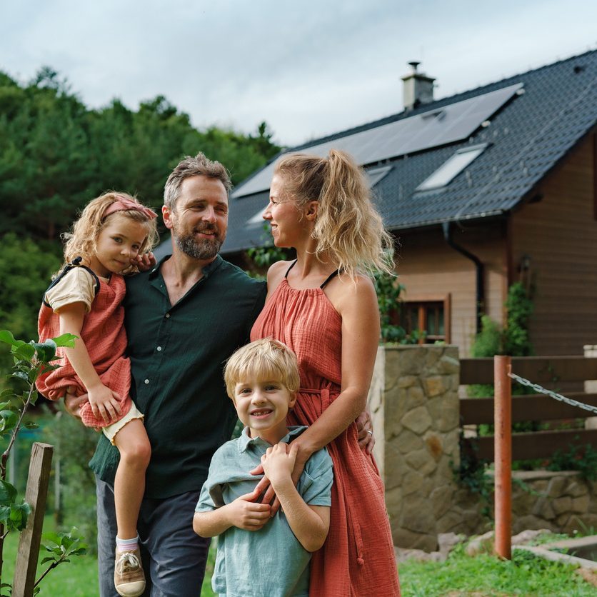 Familie mit Einfamilienhaus mit Solaranlage auf dem Dach