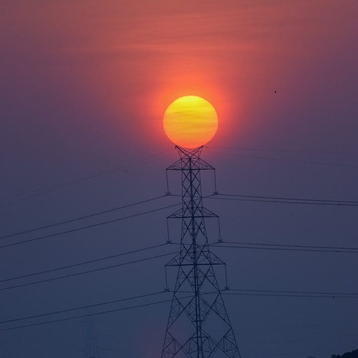 Elektrische Energie als Basis moderner Elektrospeicherheizungen Hochspannungsleitung vor Sonnenuntergang – Symbol für elektrische Energie und Stromversorgung