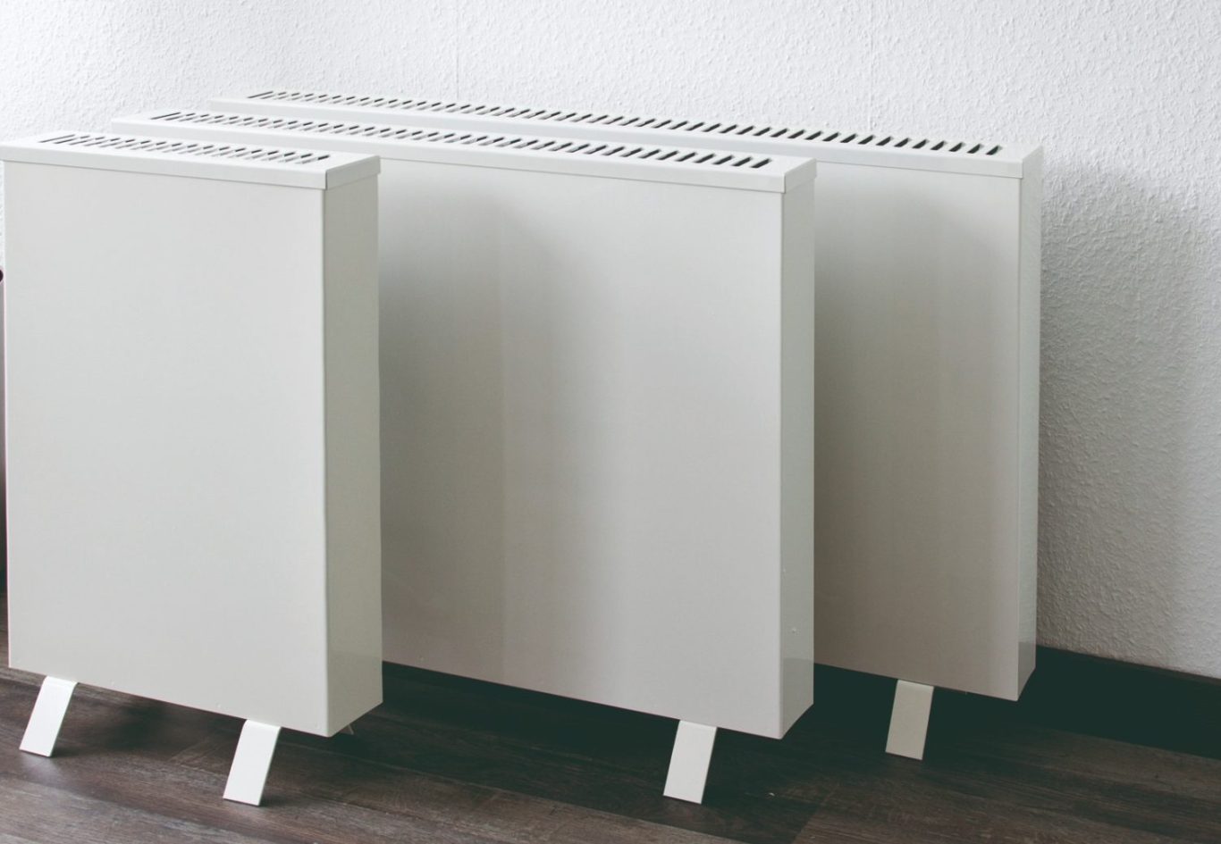 Elektrospeicherheizungen in verschiedenen Größen Elektrospeicherheizung in verschiedenen Baumformen und Abmessungen vor weißer Wand